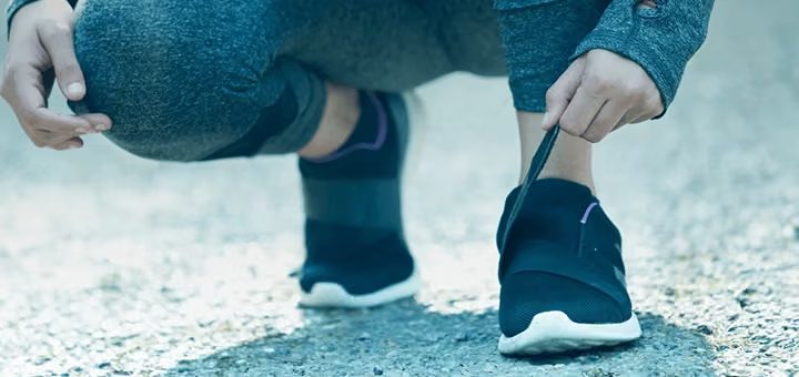 Fechamento em velcro de um calçado esportivo sendo ajustado.